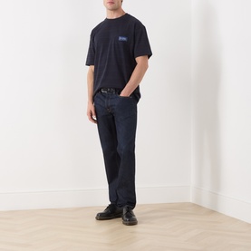 Model wearing Scotch & Soda Logo Texture Jacquard Stripe T-Shirt in Sky Captain with dark rinse jeans and black boots.