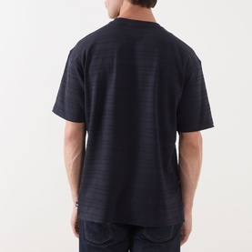 Model wearing Scotch & Soda Logo Texture Jacquard Stripe T-Shirt in Sky Captain, rear view, styled with dark denim jeans.