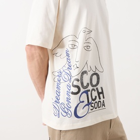 Model wearing Scotch & Soda Work-Out Art Logo T-Shirt in Eggnog, featuring bird and face graphic print with branded script detail.