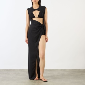 Model wearing Skims Sarong Dress in Onyx, black maxi with cut-out bust, wrap front, high thigh slit, styled with black strappy sandals