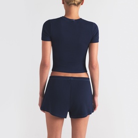 Model wearing Skims navy shorts with matching navy crop top, rear view showing relaxed fit and clean ribbed fabric finish