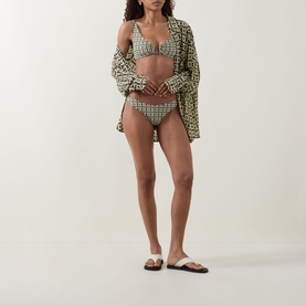 Model wearing Away That Day Navy/Gold Link Print Bikini Brief with matching triangle top and open printed shirt cover-up, white flat sandals.