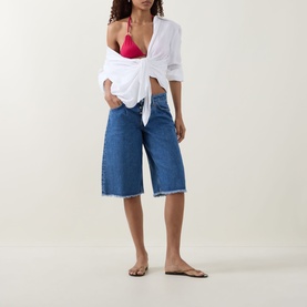 Model wearing Away That Day Raspberry Bikini Top with white knotted shirt, blue denim culottes and tan flat sandals