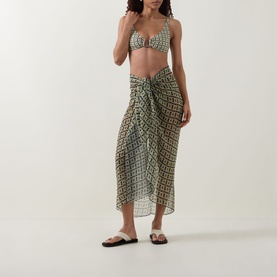 Model wearing Away That Day Navy/Gold Link Print bikini top, styled with matching sarong skirt and white slides.