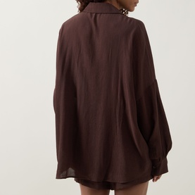 Model wearing Away That Day brown oversized cover-up shirt, back view, long sleeves, relaxed fit in viscose-polyamide blend
