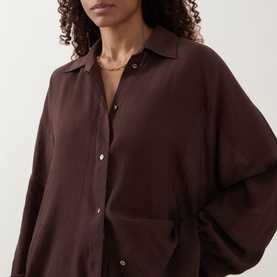 Model wearing Away That Day brown oversized button-up cover up in viscose blend, styled with a gold chain necklace