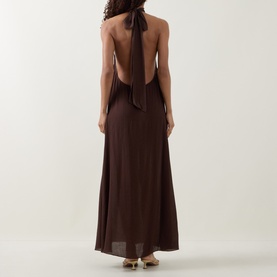 Model wearing Away That Day Espresso Crinkle Linen halterneck maxi dress with open back and tie detail, styled with gold sandals.