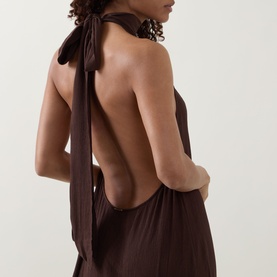 Model wearing Away That Day Espresso Crinkle Linen Dress with open back and halter neck tie detail, shown from behind.