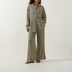 Model wearing Away That Day Navy/Gold Link Print cover up shirt and wide-leg trousers, styled with flat sandals