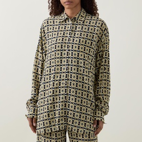 Model wearing Away That Day Navy/Gold Link Print viscose cover-up shirt, styled with matching wide-leg trousers.