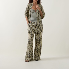 Model wearing Away That Day Navy/Gold Link Print cover-up with matching wide-leg trousers and strappy sandals.