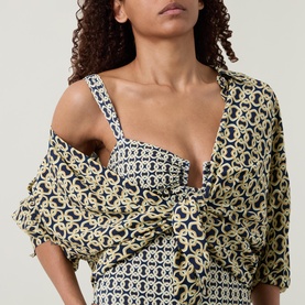 Model wearing Away That Day swimsuit in Navy/Gold Link Print, styled with matching printed wrap cover-up