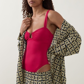 Model wearing Away That Day raspberry swimsuit with ruched bust detail, styled with a printed kimono cover-up