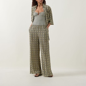 Model wearing Away That Day Navy/Gold Link Print trousers with matching printed crop top and blazer, styled with flat sandals.