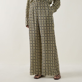 Model wearing Away That Day Navy/Gold Link Print wide-leg viscose trousers with matching long-sleeve top and brown heeled sandals.