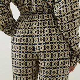 Model wearing Away That Day Navy/Gold Link Print trousers in 100% viscose, shown from waist down with matching printed top.