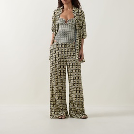 Model wearing Away That Day Navy/Gold Link Print viscose trousers with matching top, styled with strappy flat sandals.