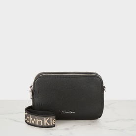 Calvin Klein Logo Camera Crossbody Bag in black faux grained finish, silver-tone hardware, with branded webbed crossbody strap