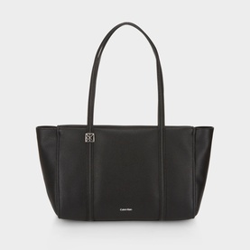 Calvin Klein black tote bag with silver-tone logo plaque, dual top handles, and structured base in smooth faux leather finish.