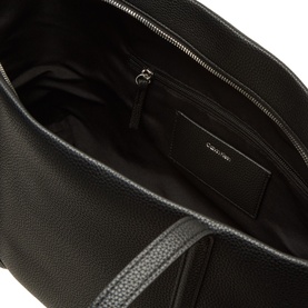 Calvin Klein black tote bag interior view, showing zip pocket, card slot, and black fabric lining with silver-tone zip detail