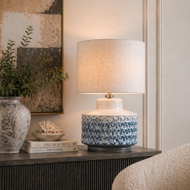Mindy Browne Esme Textured Table Lamp in blue and white ceramic with linen shade and brass detail, styled on a dark sideboard.