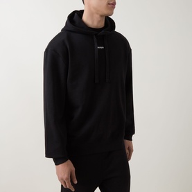 Model wearing Hugo black oversized cotton hoodie with drawstring hood and small chest logo print
