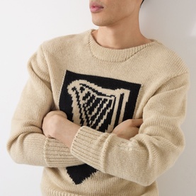 Model wearing JW Anderson Harp Knitted Sweater in ivory, featuring a bold black harp intarsia motif, crew neck, and ribbed trims