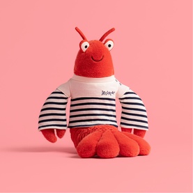 Jellycat red lobster plush toy wearing navy striped top with embroidered text, soft fluffy texture, pink background