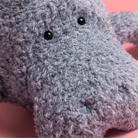 Jellycat grey fluffy hippo plush soft toy, close-up of textured curly fur face with small black eyes