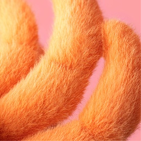 Jellycat plush soft toy in orange fluffy fur, close-up detail showing texture of curved plush limbs or body sections