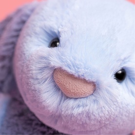 Jellycat soft plush bunny toy close-up showing lavender and pale blue fluffy face with black eyes and pink nose