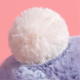 Jellycat plush soft toy in lilac and white, close-up detail of fluffy white pom-pom on top against pink background