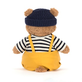 Jellycat bear plush toy, rear view, wearing navy knit hat, striped top and yellow dungarees, medium size