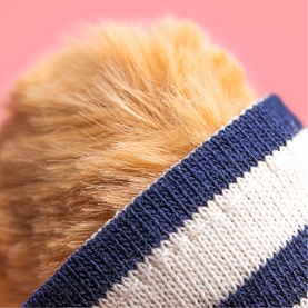 Jellycat plush soft toy close-up showing fluffy golden fur and navy blue and white striped knit fabric detail