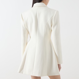 Model wearing Odd Muse cream blazer dress, rear view, structured shoulders, fitted waist, flared skirt, long sleeves.