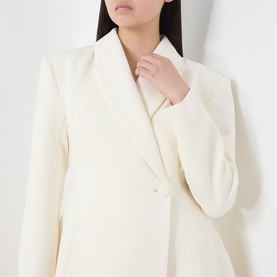 Model wearing Odd Muse cream dress with tailored blazer-style lapels and structured shoulders, single-button fastening.