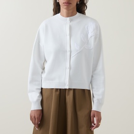 Model wearing Ted Baker Neslie Applique Rose Ivory Cardigan with crew neck and long sleeves, styled with khaki wide-leg trousers
