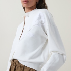 Model wearing Ted Baker Neslie Applique Rose Ivory Cardigan with dropped shoulders, styled with khaki trousers