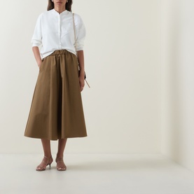 Model wearing Ted Baker Neslie Ivory Applique Rose Cardigan styled with an olive midi skirt and nude heeled sandals.