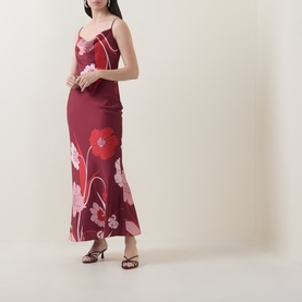 Model wearing Ted Baker Indora Floral Slip Dress in dark red satin with cowl neck, floral print, and flared maxi hem, styled with heeled sandals.