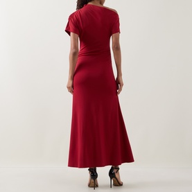 Model wearing Ted Baker Maevely Asymmetric Flared Dress in red, maxi length with flared skirt, styled with black heels, back view.