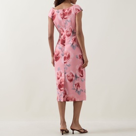 Model wearing Ted Baker Odeta Floral Fitted Dress in coral, midi length, floral print, cap sleeves, rear view with tan mules.