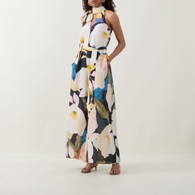 Model wearing Ted Baker Camea Floral Print Jumpsuit in Navy with halter neck, wide-leg silhouette and bold floral print, styled with tan heeled