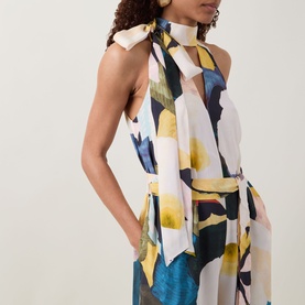 Model wearing Ted Baker Camea Floral Print Jumpsuit in Navy with halter neck, tie detail, front cut-out, and wide-leg silhouette