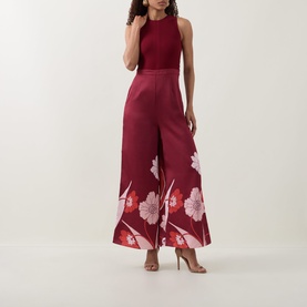 Model wearing Ted Baker Izeny Placement Floral Jumpsuit in dark red, sleeveless with wide-leg floral print trousers and fitted waist.