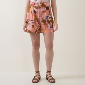 Model wearing Ted Baker Noysa Floral Print Shorts in coral with large floral print, matching belt, styled with brown strappy sandals