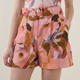 Model wearing Ted Baker Noysa Floral Print Shorts in coral, mid-rise with front pleats, matching belt and abstract floral print.