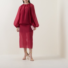 Model wearing Ted Baker Deka Semi-Sheer Dark Red Midi Skirt with matching red blouse and nude strappy heels, carrying a pink clutch.