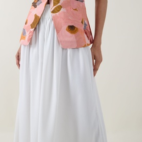 Model wearing Ted Baker Bracci Pleated Wide-Leg Trousers in ivory, styled with a pink floral cropped jacket. High-rise, fluid silhouette.