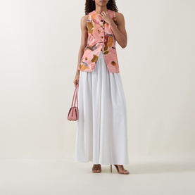 Model wearing Ted Baker Bracci Pleated Wide-Leg Trousers in ivory, styled with a pink floral top, heels and mini bag.